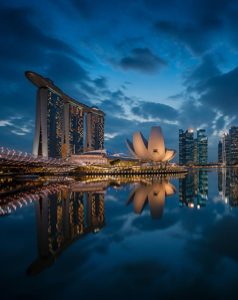 Singapore Marina Bay skyline reflected in still water at blue hour